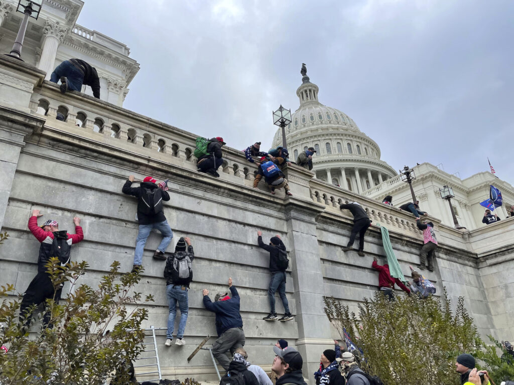 People scaling the outer wall of the U.S. Capitol on Jan. 6, 2021.